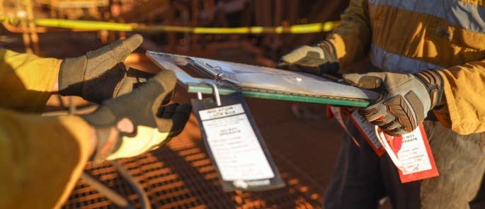Workers reviewing permit to work document